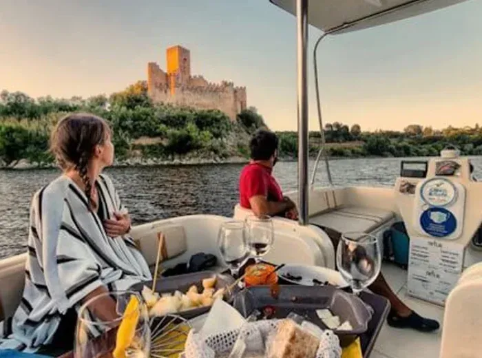 Almourol Castle in the background with two guests enjoying a private river cruise